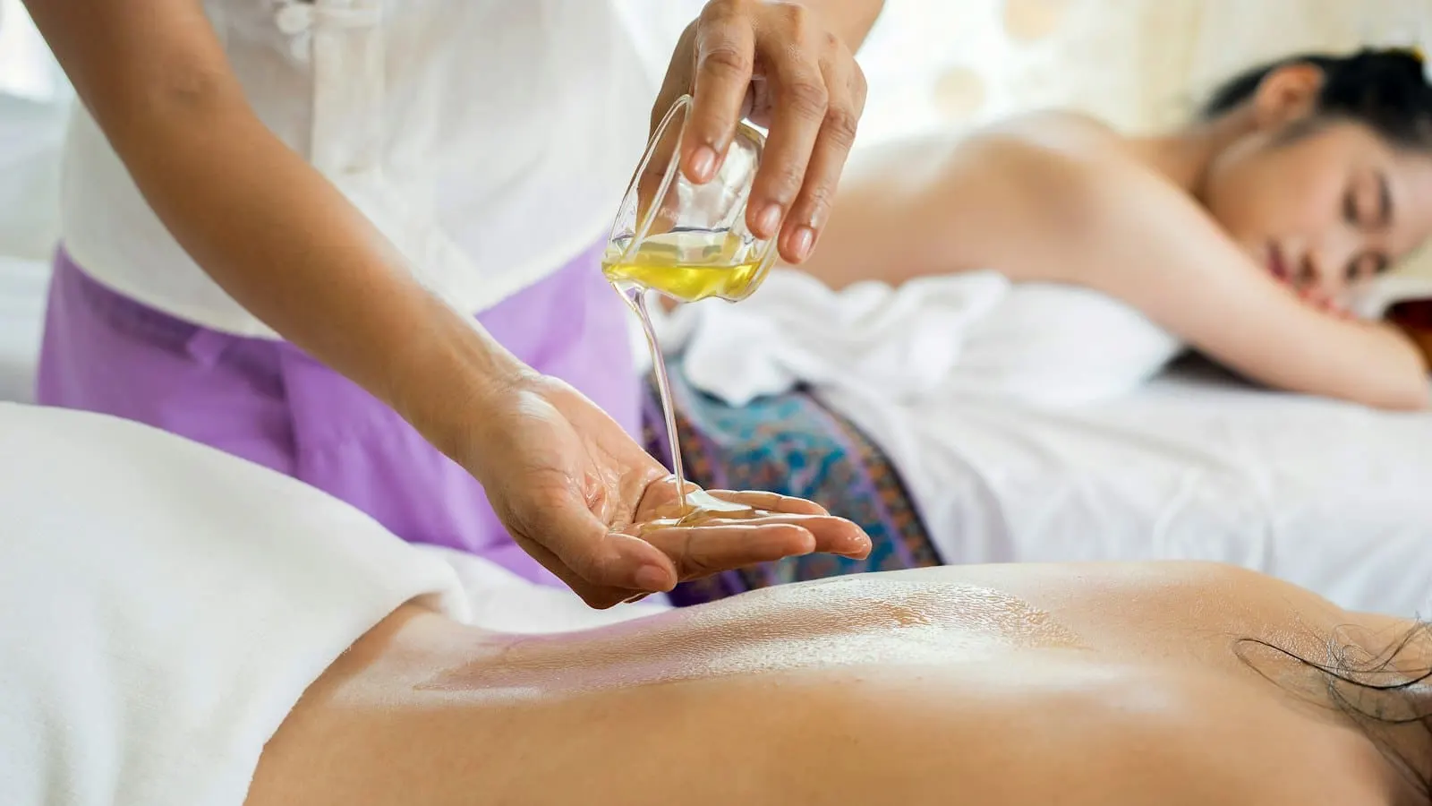 Massage drainant à l'huile sur le dos, dans une ambiance spa apaisante
